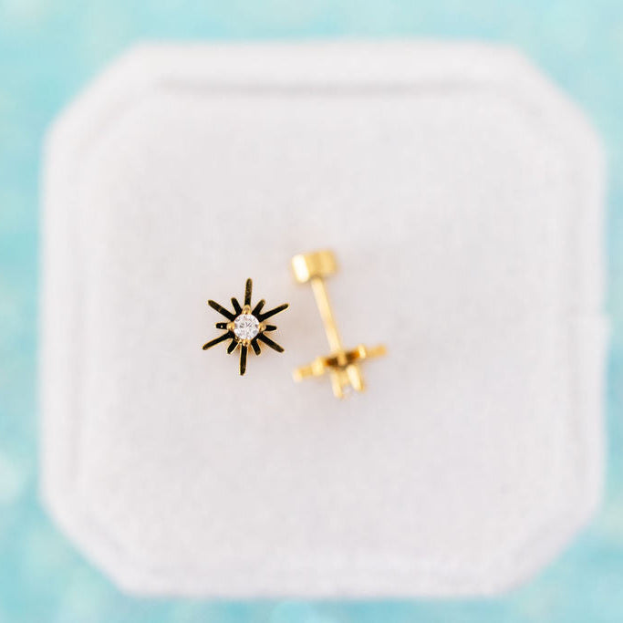 Starburst CZ Stud Earrings on a white jewelry box on a teal background