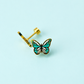 Pair of teal colored enamel butterfly stud earrings on a light blue background