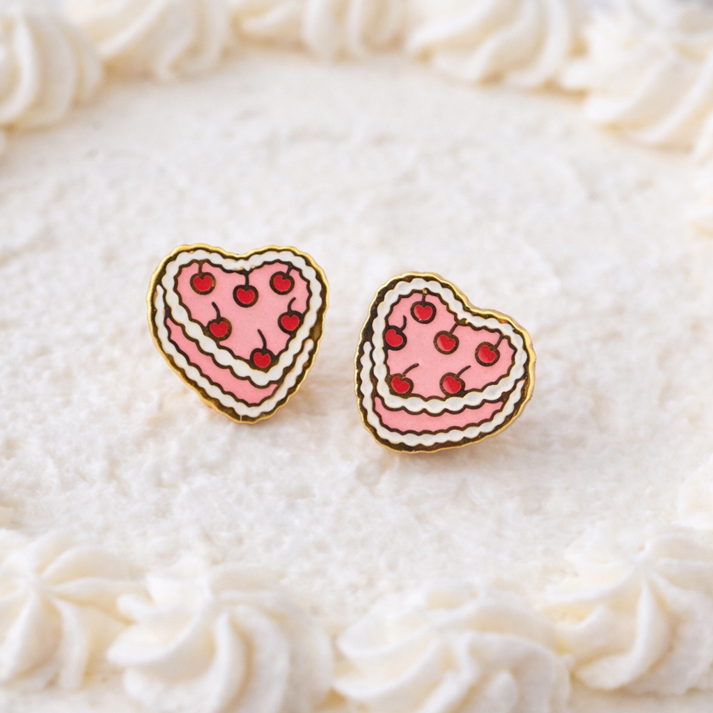 Vintage heart cake earrings on a white fluffy cake background